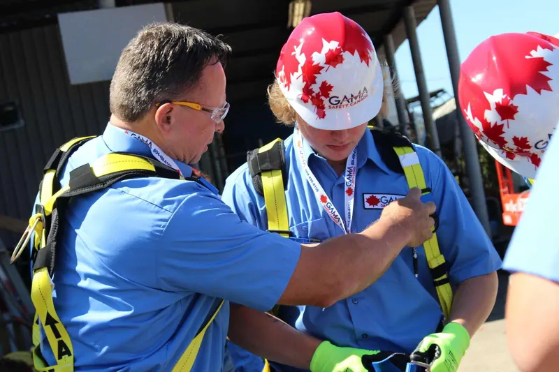 Instructor fitting a full-body harness on a fall protection trainee