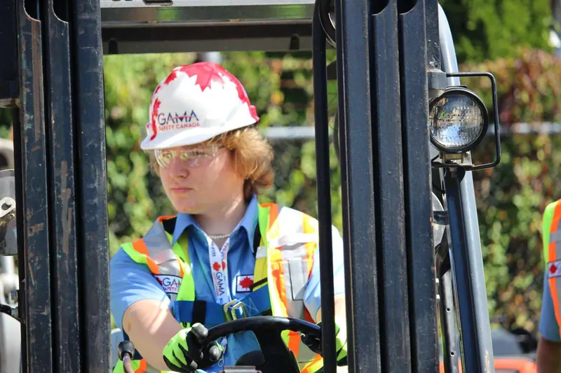 Forklift trainee in a Gama Safety hard hat operating the controls