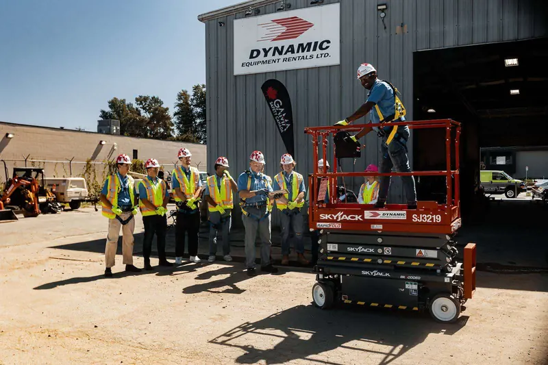 Trainee demonstrating a scissor lift while the class watches